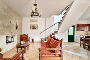 salon ze schodami i kamienną ścianą w obiekcie Villa Elia by PosarelliVillas w mieście Vryses