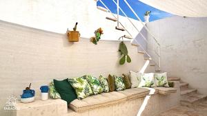 a couch with pillows on a wall with stairs at Paradise Sea Terrace in Monopoli