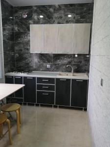 a kitchen with black cabinets and a sink and a table at U Vili in Pizunda