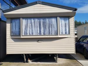 a tiny house with a window in a driveway at Caravan on Golden Gate Holiday Park in Kinmel Bay