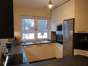 a kitchen with a stainless steel refrigerator and a window at Onufrowy Dworek in Ruciane-Nida