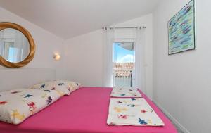 un letto in una camera con una coperta rosa e uno specchio di Apartments Villa Filip a Trogir