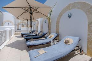 - un ensemble de chaises et de parasols bleus sur un balcon dans l'établissement Dar Benti, à Monastir