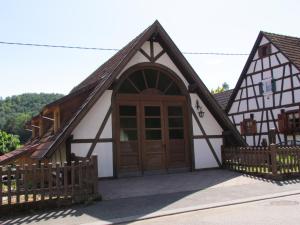 una casa con una puerta de madera y una valla en Gîte des Chateaux-forts, en Obersteinbach