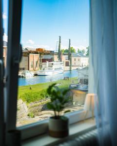a window with a view of a boat in the water at Byggmästare Villan in Motala