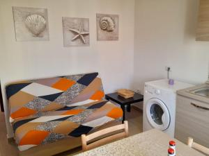 a laundry room with a chair and a washing machine at Grazioso bilocale in centro in Lotzorai