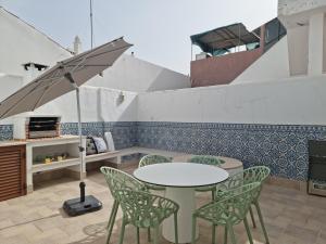 een tafel en stoelen met een parasol op een patio bij Cabanas de Tavira Unique, Luxury 2,5 bedroom House 50 meters to the water in Cabanas de Tavira