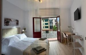 a bedroom with a bed and a large window at APARTAMENTOS SANTULLANO 2 in Oviedo