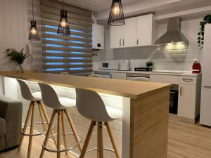 a kitchen with white cabinets and a wooden counter top at APARTAMENTOS SANTULLANO 2 in Oviedo