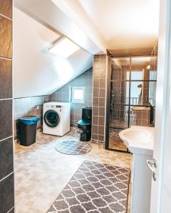 a bathroom with a washing machine and a washer and dryer at Byggmästare Villan in Motala