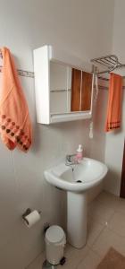 a bathroom with a white sink and a toilet at Apartamentos Guiomar Campos in Porto Covo
