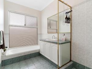 a bathroom with a tub and a sink at Aqua La Vista Mandurah in Mandurah +27 photos
