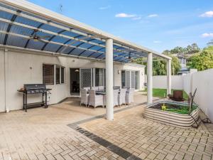 a covered patio with a table and a grill at Aqua La Vista Mandurah in Mandurah