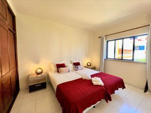 um quarto com uma cama com um cobertor vermelho e uma janela em Algarve Manta Rota Beach by Homing em Manta Rota