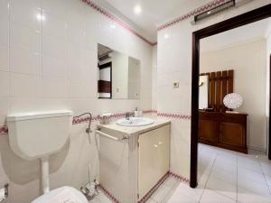 a bathroom with a toilet and a sink and a mirror at Algarve Manta Rota Beach by Homing in Manta Rota +16 photos
