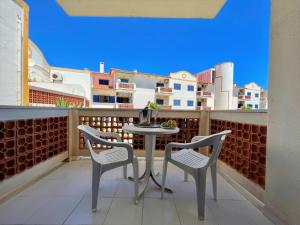 a small table and chairs on a balcony with a city at Algarve Manta Rota Beach by Homing in Manta Rota