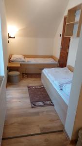 シオーフォクにあるÁdám Vendégházのベッド2台が備わるウッドフロアの小さな客室です。
