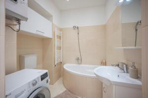 een badkamer met een wasmachine en een wastafel bij Design Home @ Rumbach in Boedapest