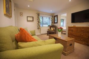 a living room with a green couch and a tv at Little Forge in Saint Mawgan