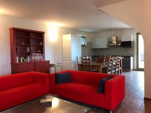 uma sala de estar com um sofá vermelho e uma cozinha em Charming 3 Bed Villa in Otricoli stunnings views em Otricoli