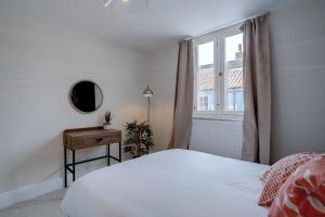 a bedroom with a white bed and a window at Stunning designer apartment in an ancient building in Norwich