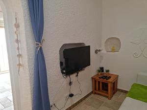 a room with a tv on a wall at Cabanas de Tavira Unique, Luxury 2,5 bedroom House 50 meters to the water in Cabanas de Tavira