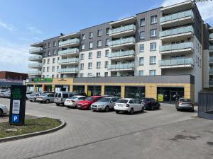 un estacionamiento con autos estacionados frente a un edificio en SDH 1 Radzymin comfortable apartment near Warsaw, en Radzymin