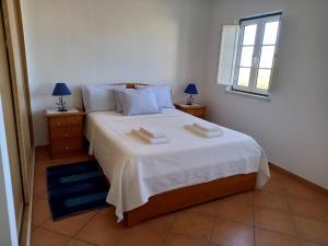 米尔芳提斯城T2,Casa Sol e Mar 50464/AL的卧室里有一张白色的大床和两个床头柜