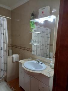 a bathroom with a sink and a mirror at T2,Casa Sol e Mar 50464/AL in Vila Nova de Milfontes