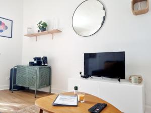 uma sala de estar com uma televisão e uma mesa em Confortable T2 sur les rives de la Charente em Angoulême