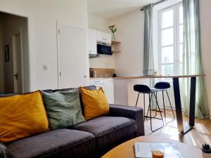 a living room with a couch and a kitchen at Confortable T2 sur les rives de la Charente in Angoulême