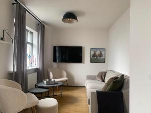 a living room with a couch and a tv at Lítið einbýlishús á besta stað. in Vestmannaeyjar