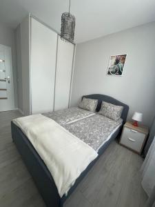 um quarto com uma cama com uma parede branca em Kazimierza Wielkiego 32 em Gdansk