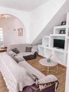 Una sala de estar con un sofá y un televisor. en GreenTree House, en Corralejo 24 fotos más