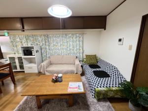 a living room with a couch and a table at 別府ホーム in Beppu