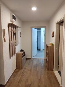 a room with a hallway with wooden floors and a door at Mikmari apartman in Subotica