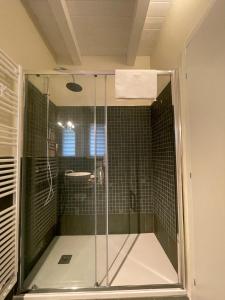 a shower with a glass door in a bathroom at Pioppi Neri R&B in Felino