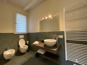 a bathroom with a toilet and a sink and a mirror at Pioppi Neri R&B in Felino +45 photos