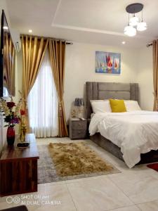 a bedroom with a large bed and a window at Professionals Friendly with Work Station PS5 & near Beaches in Lekki