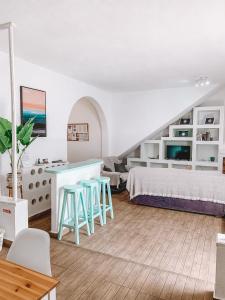 1 dormitorio con cama, mesa y taburetes en GreenTree House, en Corralejo
