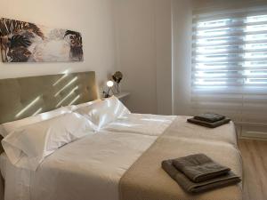 a bedroom with a bed with two towels on it at APARTAMENTOS SANTULLANO 2 in Oviedo