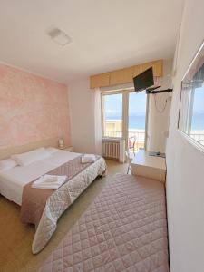 a hotel room with a bed and a window at Hotel Ambassador in Laigueglia