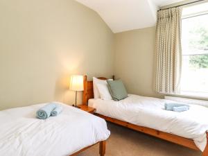 two beds in a room with a window at 1 Lake View in Coniston