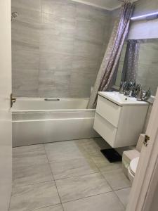Un baño con bañera, inodoro y lavabo. en Modern 2 bedroom flat with Sky TV & free parking, en Dagenham 20 fotos más