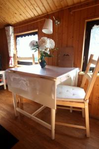 une table et une chaise avec un vase de fleurs dans l'établissement Ferienhaus beim Imker, à Marienberg