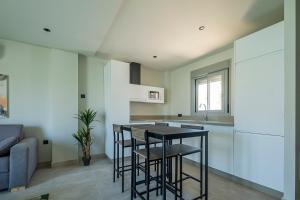 a kitchen with a black table and chairs in a room at ON City Apartments in Matalascañas