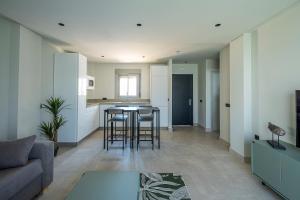 a living room and kitchen with a table and chairs at ON City Apartments in Matalascañas