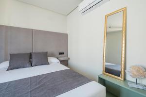 a bedroom with a bed and a mirror at ON City Apartments in Matalascañas +37 photos