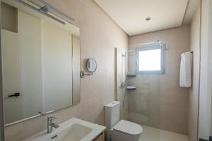 a bathroom with a toilet and a sink and a mirror at ON City Apartments in Matalascañas