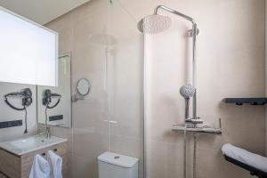 a bathroom with a shower and a toilet and a sink at ON City Apartments in Matalascañas